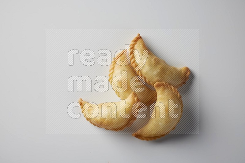 Four fried sambosa from a top angle on a white background