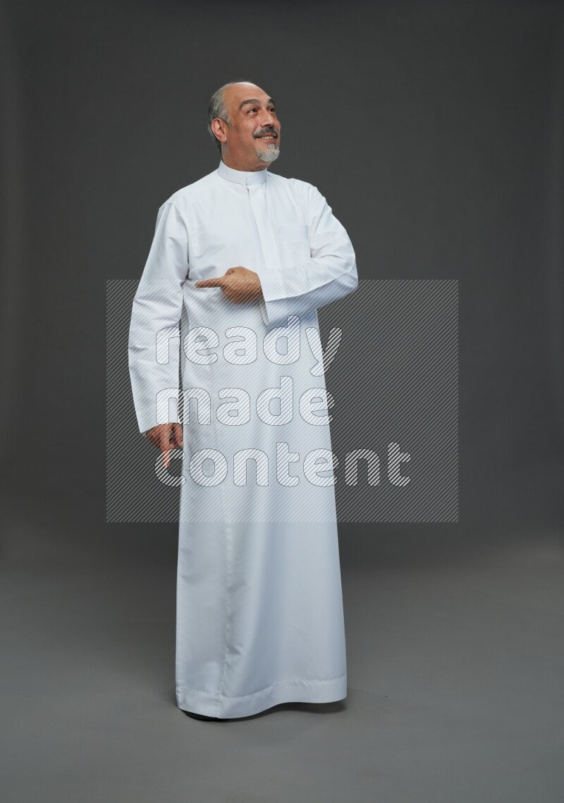 Saudi man without shomag Standing Interacting with the camera on gray background