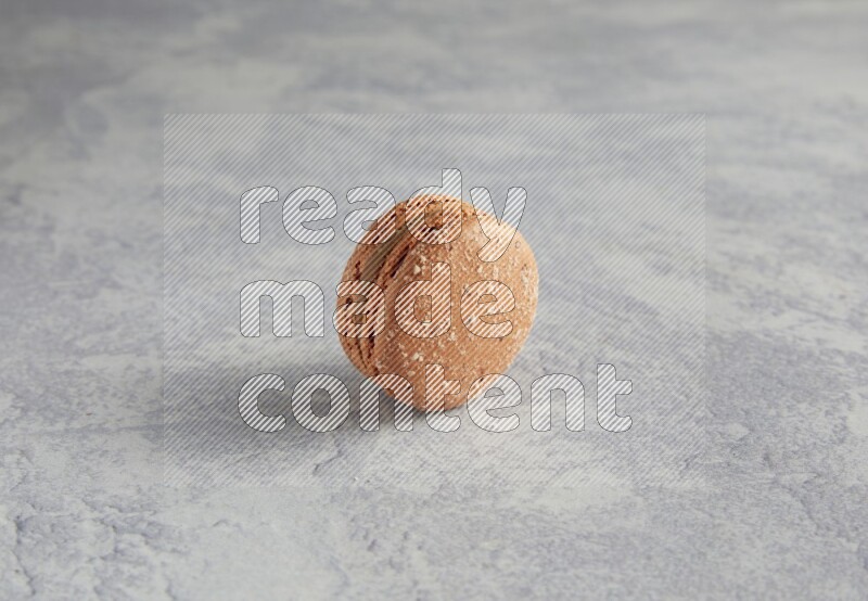 45º Shot of Brown Hazelnuts macaron on white  marble background