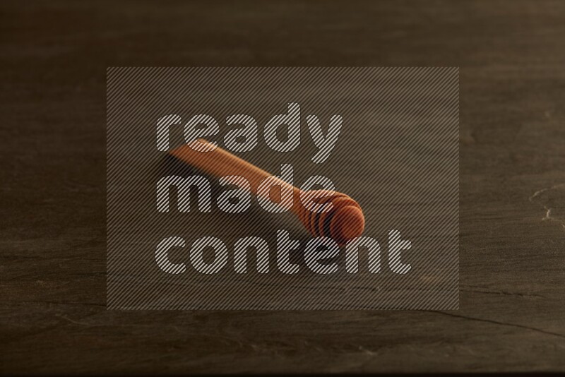 Wooden honey dipper on black slate background