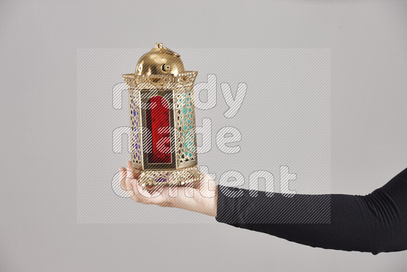 A woman in black abaya holding different ramadan lanterns in different positions