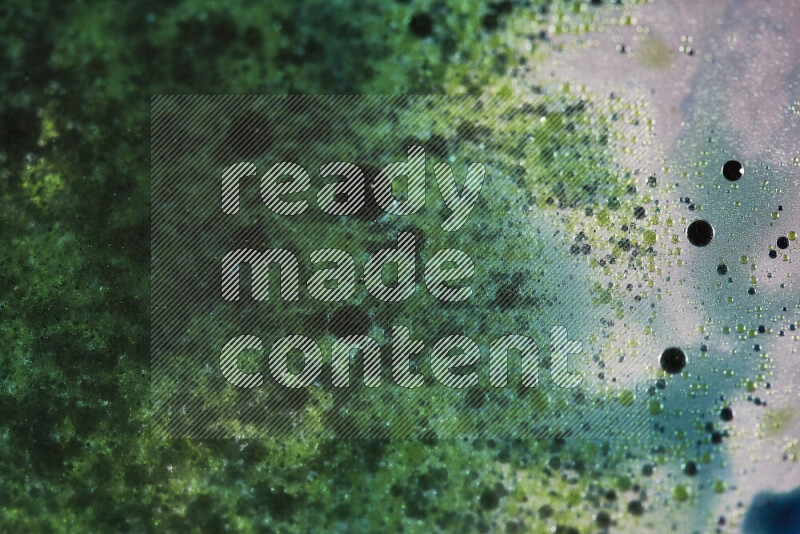 لقطات مقربة لقطرات ألوان مائية خضراء وزرقاء على سطح الزيت على خلفية بيضاء