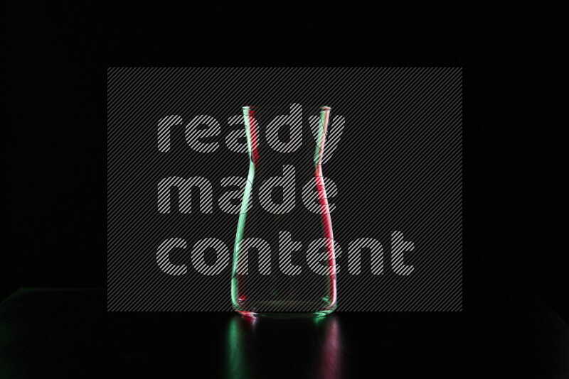 Glassware with rim light in red and green against black background