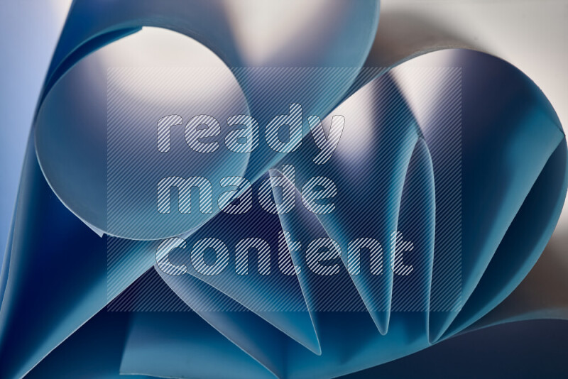 عرض فني لطيات الورق تخلق مزيج من الأشكال الهندسية، مضاءة بإضاءة ناعمة بدرجات اللون الأزرق