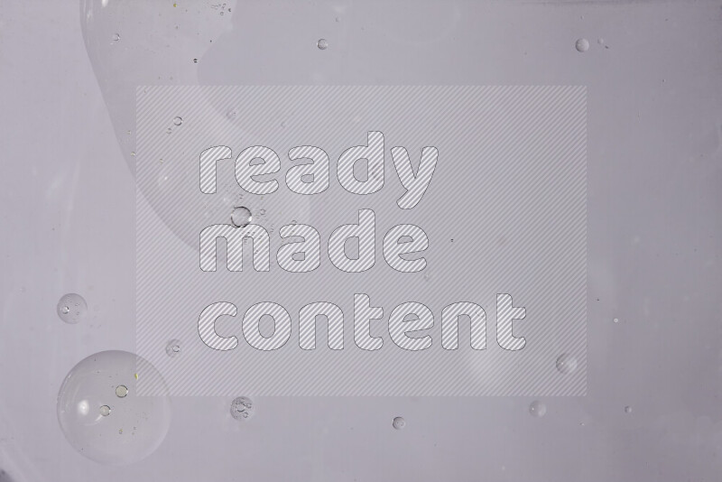 قطرات من الزيت على سطح الماء على خلفية بيضاء