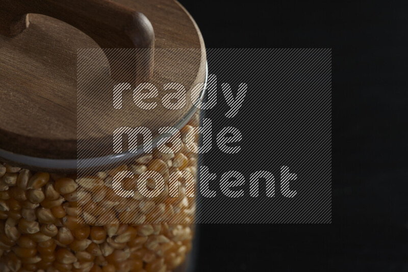 Pop corn in a glass jar on black background