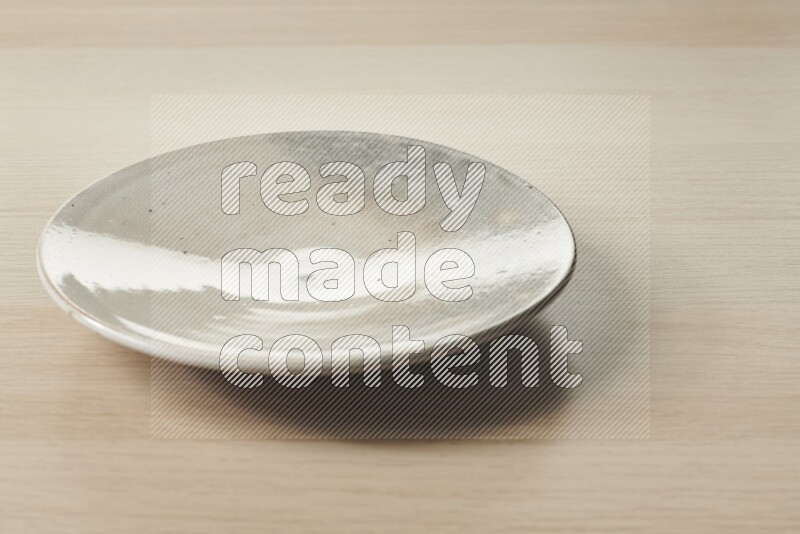 A multicolored pottery plate on light wooden background