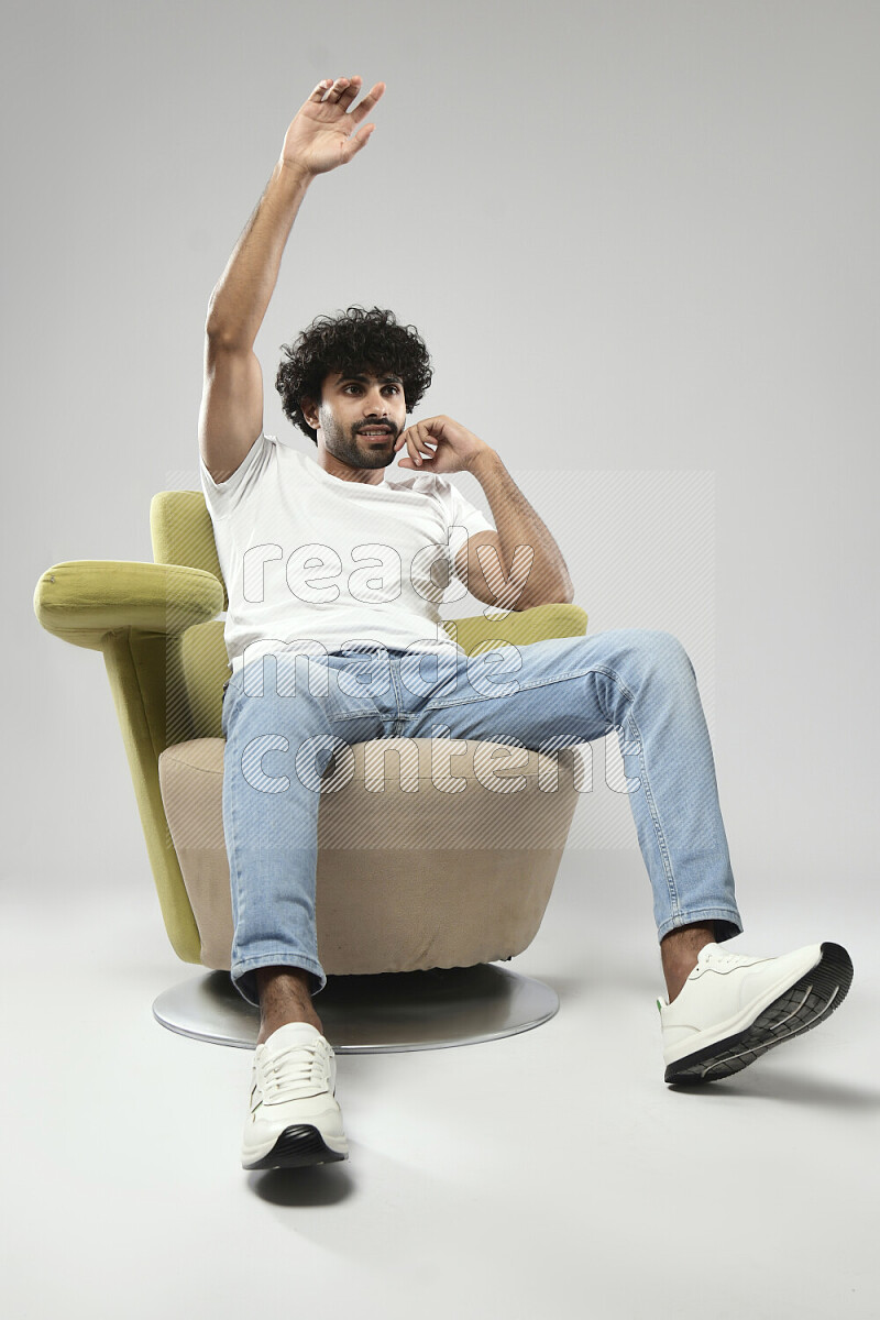 A man wearing casual sitting on a chair making a hand gesture on white background