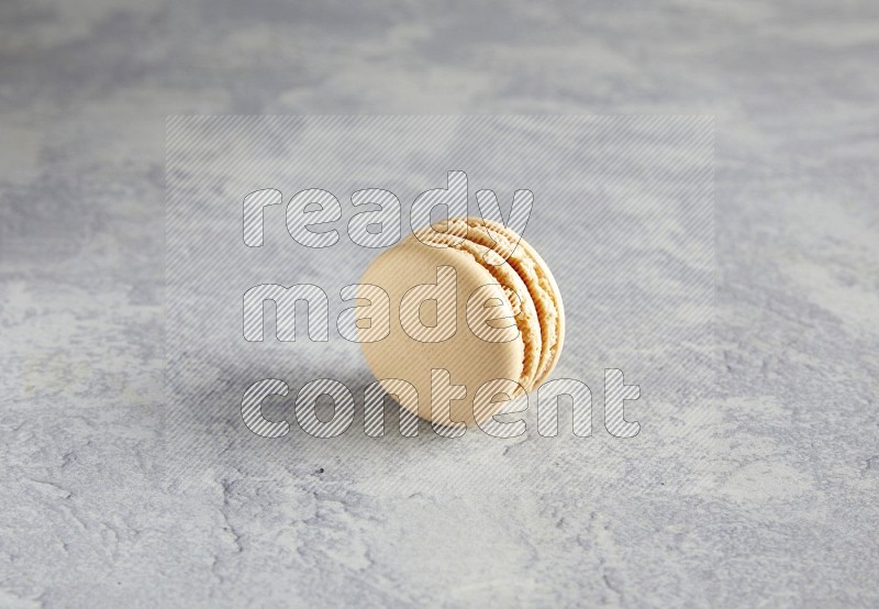 45º Shot of white marbleCaramel fleur de sel macaron on white  marble background