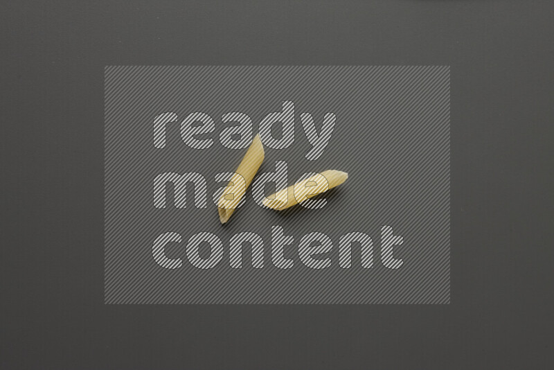 Mini penne pasta on grey background