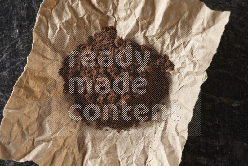 بودرة القرنفل في قطعة من الورق على أرضية سوداء