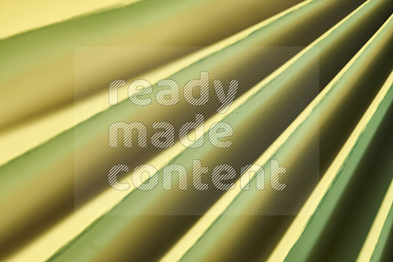 An image presenting an abstract paper pattern of lines in green and gold tones