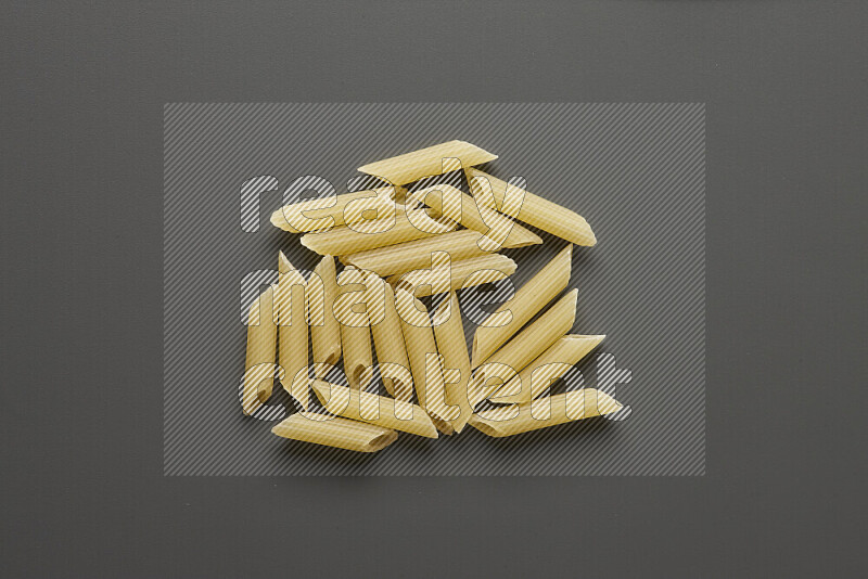 Mini penne pasta on grey background