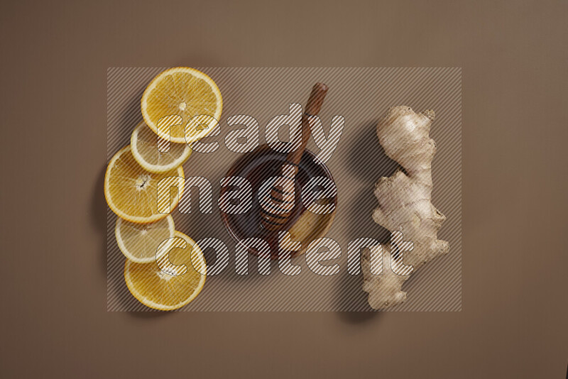 Fresh ginger root with different ingredients such as lemon, orange, honey, ground ginger on beige baackground