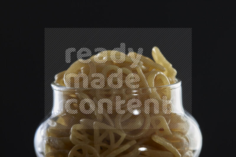 Snacks in a glass jar on black background