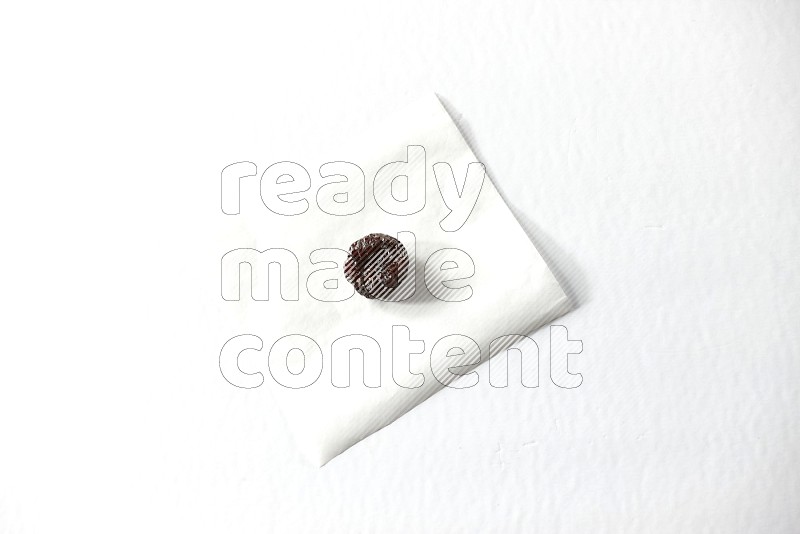 A dried plum on a piece of paper on a white background in different angles