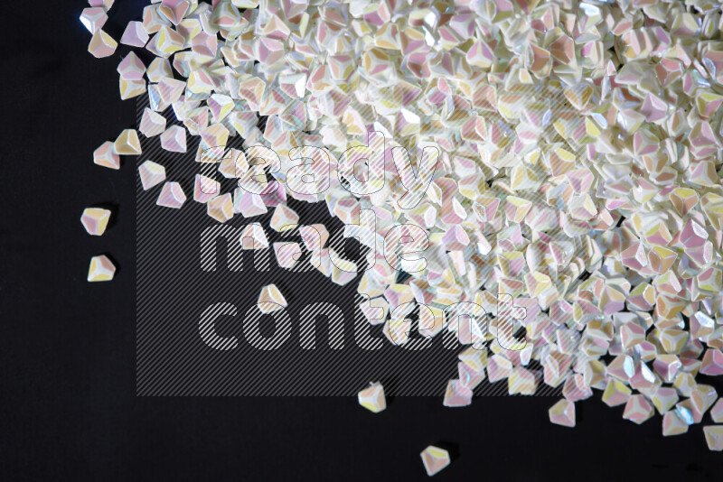 Colorful plastic shards for decoration scattered on a black background