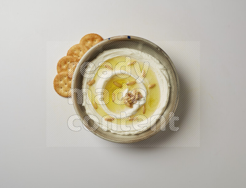 Lebnah garnished with pine nuts in a grey pottery plate on a white background