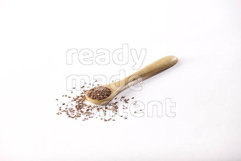 A wooden spoon full of flax on a white flooring in different angles