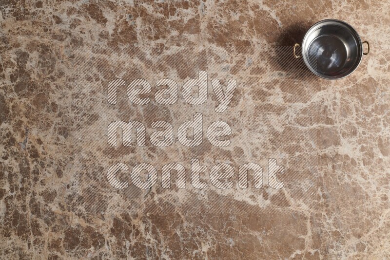 وعاء نحاسي صغير على خلفية من الرخام البيج