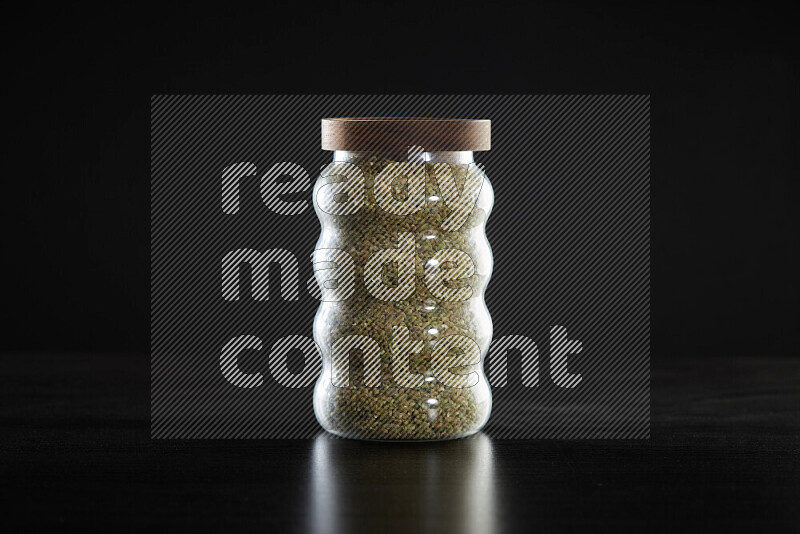 Freekeh in a glass jar on black background