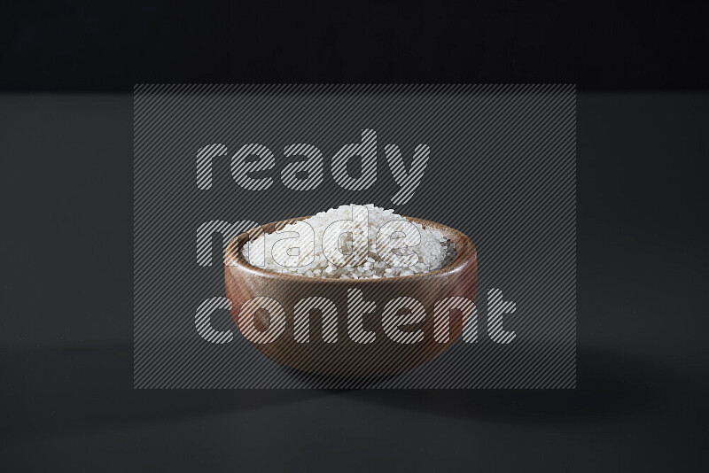 White rice in a wooden bowl on grey background