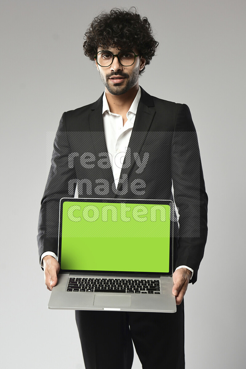 A man wearing formal standing and showing a laptop screen on white background