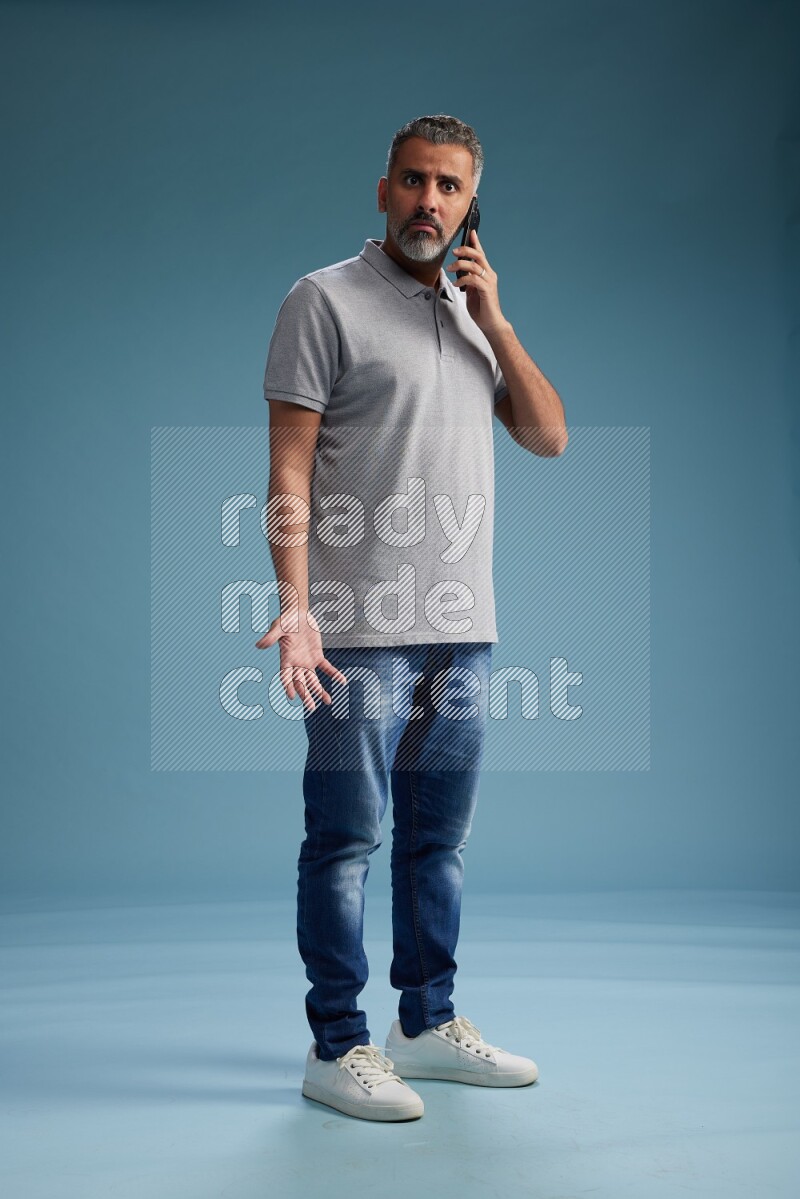 Man Standing talking on phone on blue background