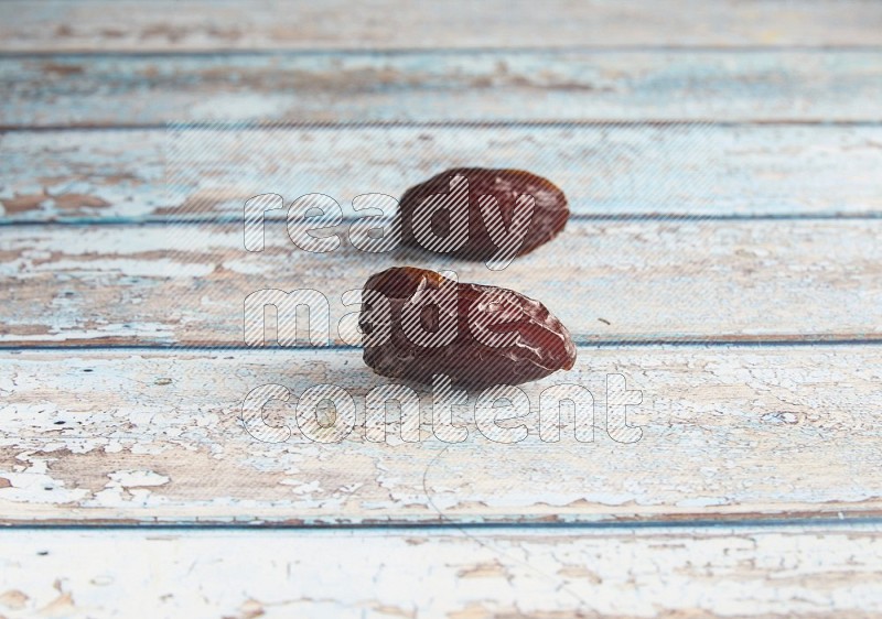 two madjoul dates on a light blue wooden background