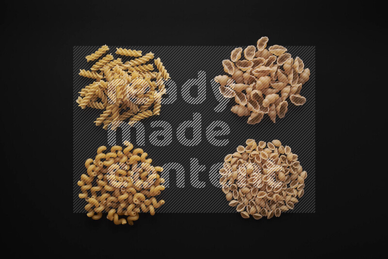 Different pasta types in bunches on black background