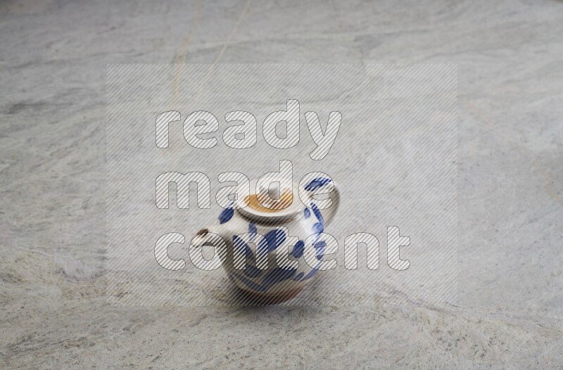 A pottery teapot on grey marble background