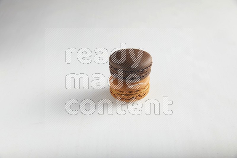 45º Shot of of two assorted Brown Irish Cream, and Brown Dark Chocolate macarons on white background