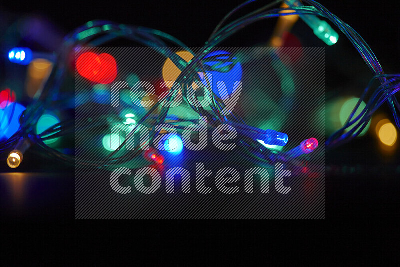 Light bulbs glowing against backdrop of multicolord bokeh