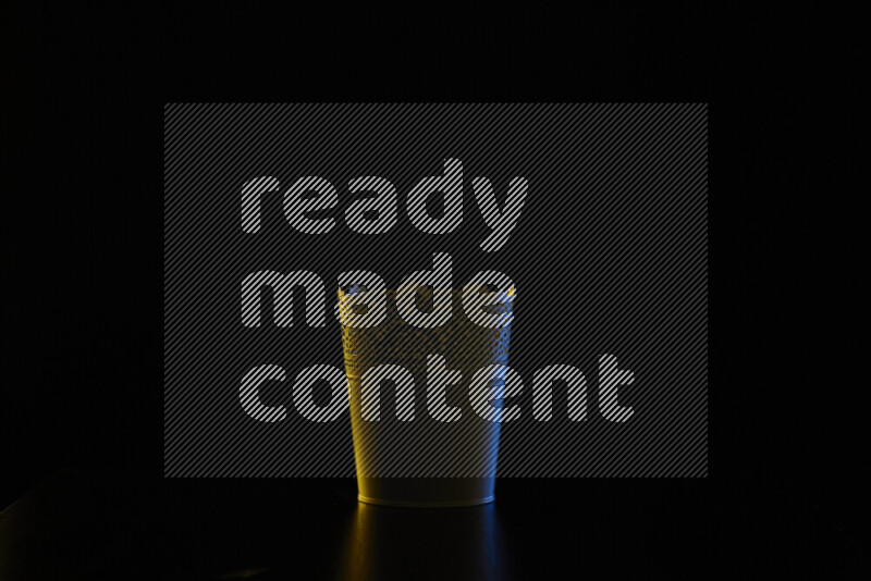 A plant pot with colored rim light against black background