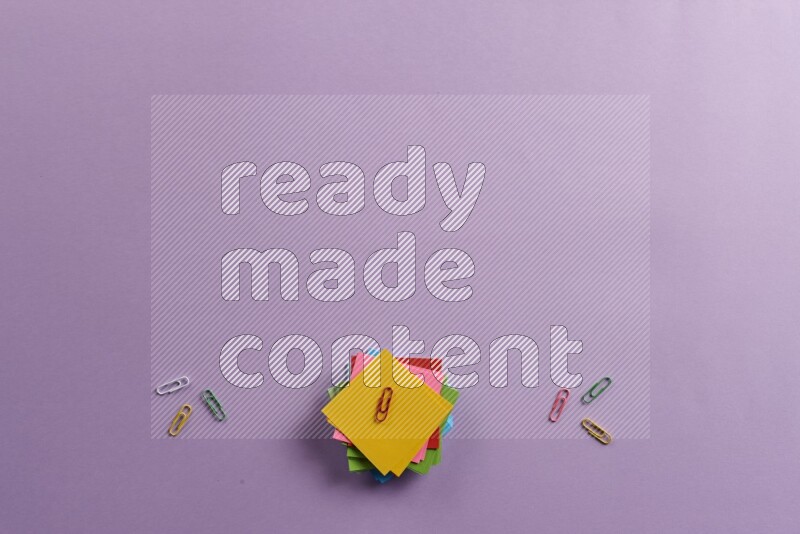 ورق ملاحظات متعدد الألوان مع مستلزمات مدرسية على خلفية أرجوانية