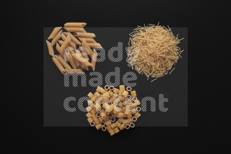 Different pasta types in bunches on black background