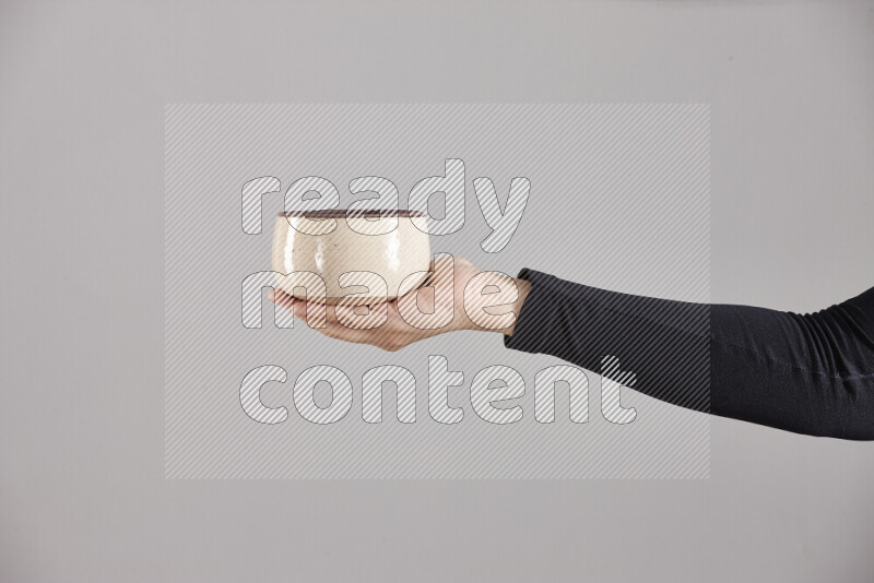 A woman in black abaya holding different pottery essentials in different positions