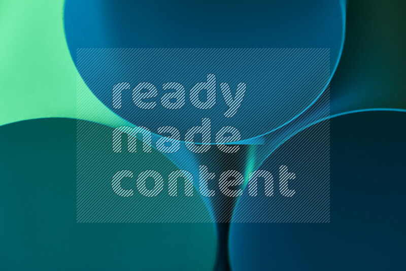 The image shows an abstract paper art with circular shapes in varying shades of green and blue