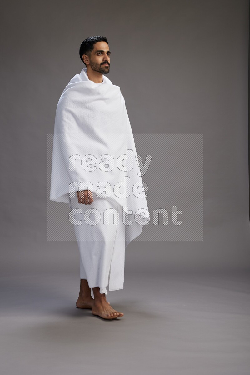 A man wearing Ehram Standing Interacting with the camera on gray background