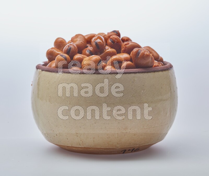 Close up shot of cooked fava beans (foul) in a container on white background