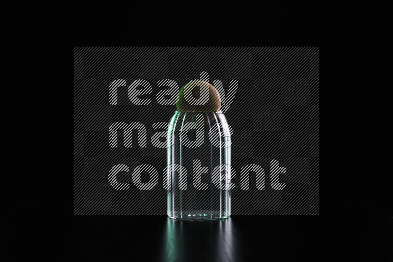 Glassware with rim light in green and white against black background