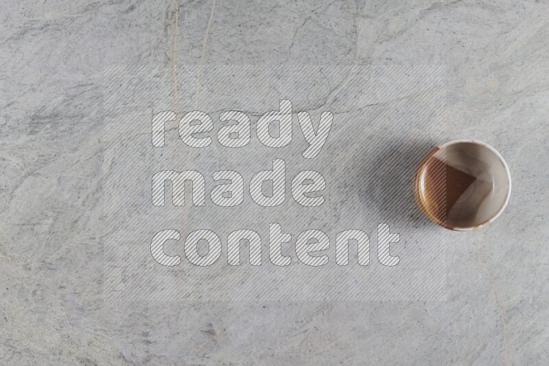 وعاء فخاري متعدد الألوان على خلفية من الرخام الرمادي