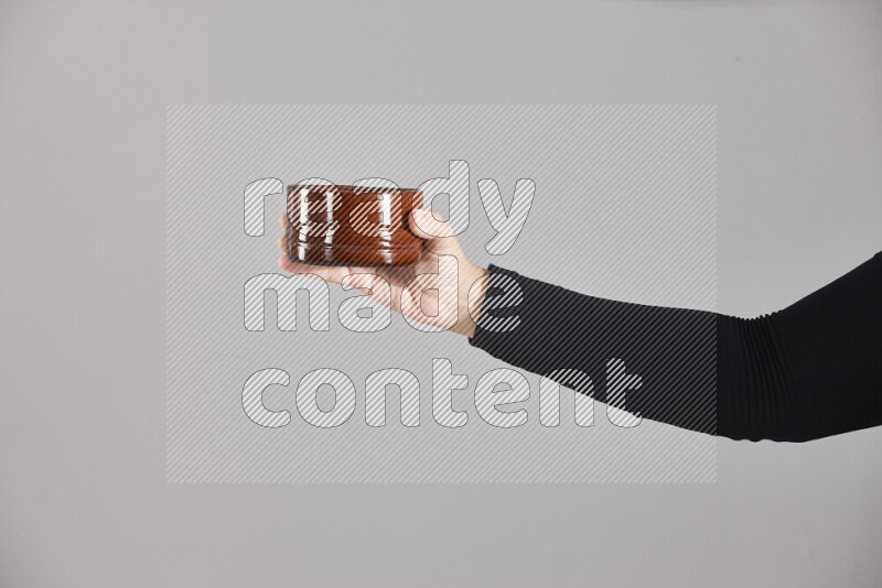 امرأة ترتدي عباءة سوداء تحمل أدوات فخارية مختلفة في أوضاع متعددة