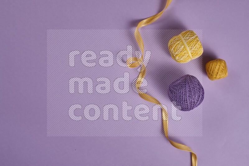 A yellow and purple collection of sewing and tailoring tools arranged on a purple background