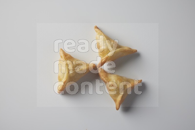 Three fried sambosa from a top angle on a white background