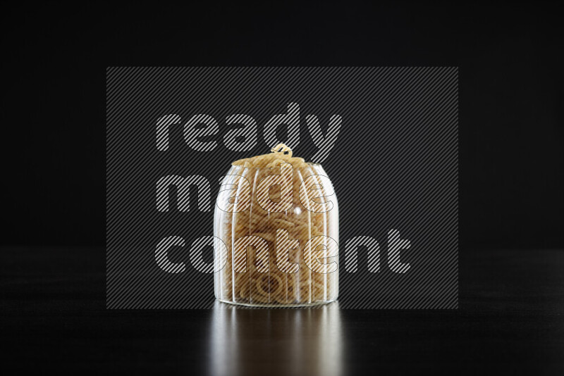 Snacks in a glass jar on black background