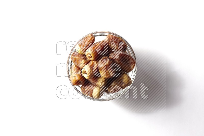 Dates in a glass bowl on white background
