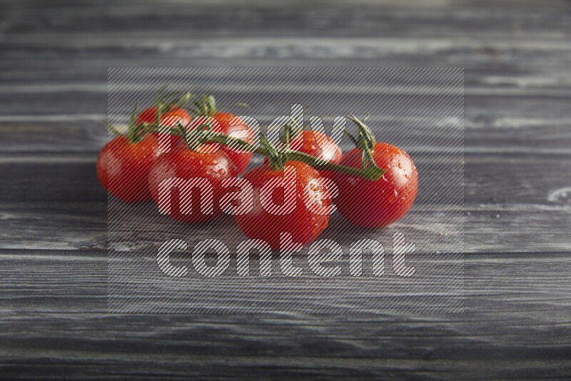 Red cherry tomato vein on a textured grey wooden background 45 degree
