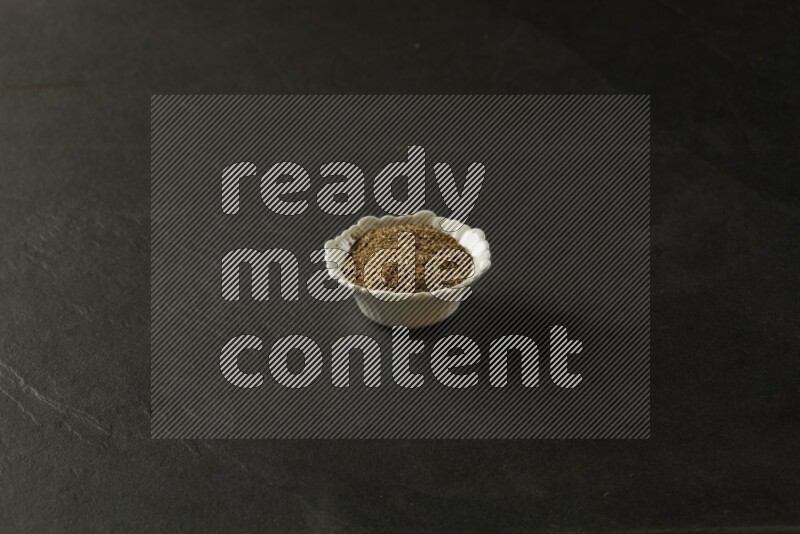 wooden round sauce bowl filled with herbs on grey textured countertop
