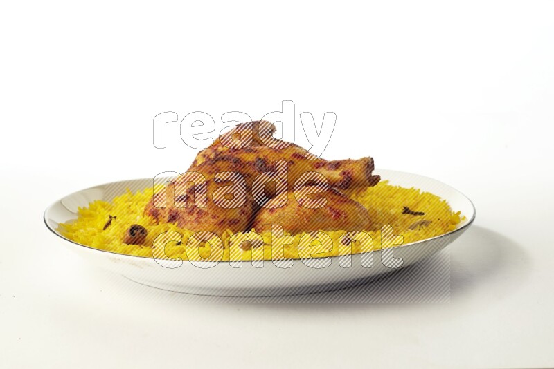 yellow  basmati Rice with kabsa chicken pieces on a white plate with a silver rim direct on white background